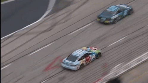 Two Race Cars Racing on Track with Large Logo