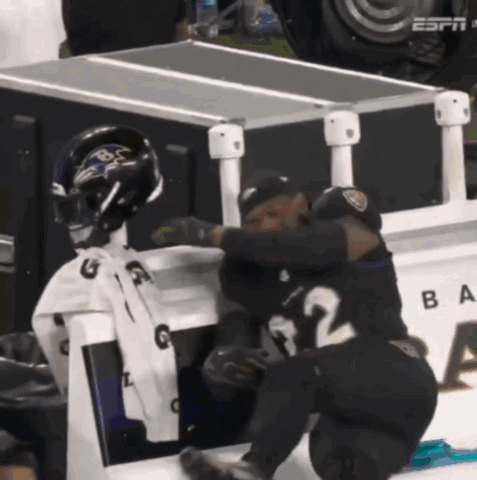 Two Ravens Players Hugging in Front of ESPN Box