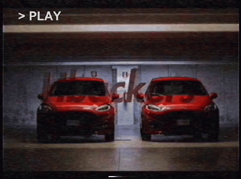 Two Red Cars Are Parked Next To Each Other In A Garage With The Word Play Visible In The Corner GIF