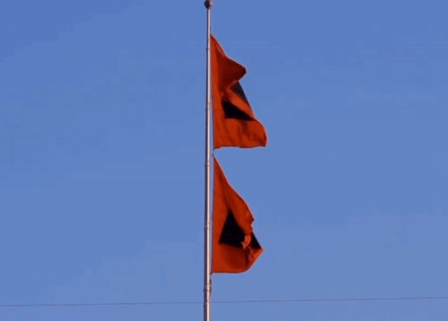 Two Red Flags With Black Squares Flying