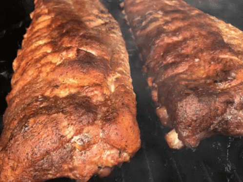 Two Ribs Cooking on Grill With Smoke