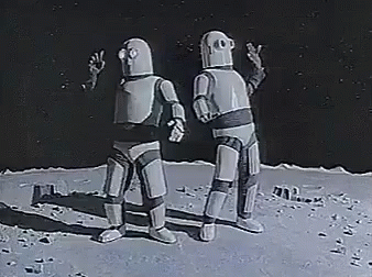 Two Robots Are Standing Next To Each Other On The Moon And Talking To Each Other . GIF