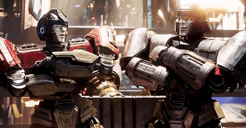 Two Robots Standing Together One With Number 10 On Head GIF