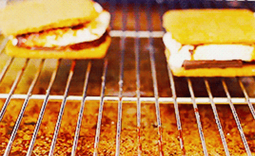 Two S'mores Are Being Cooked On A Grill .. GIF