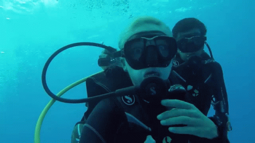 Two Scuba Divers Are Taking A Selfie In The Water GIF