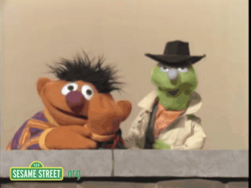 Two Sesame Street Characters Looking Over Wall