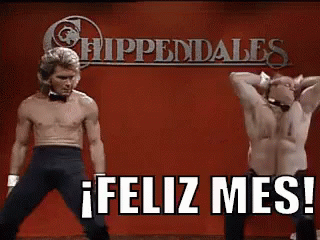 Two Shirtless Men Are Dancing On A Stage In Front Of A Sign That Says Feliz Mes ! GIF