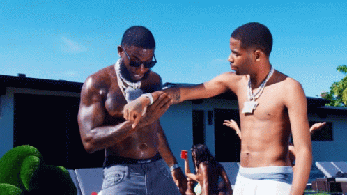 Two Shirtless Men Are Standing Next To Each Other And One Of Them Has A Tattoo On His Arm GIF