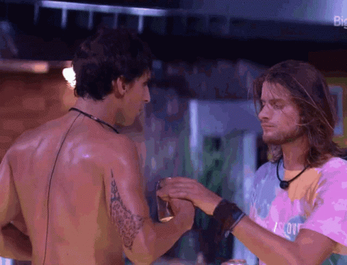 two shirtless men are standing next to each other and one of them is wearing a shirt that says ' i love you '