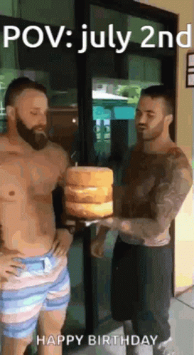 two shirtless men are standing next to each other holding a stack of cakes .