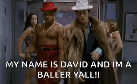 Two Shirtless Men One in Red Hat and Fur Coat