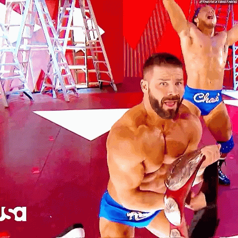 Two Shirtless Wrestlers In Blue Shorts With The Word Chas On Them GIF