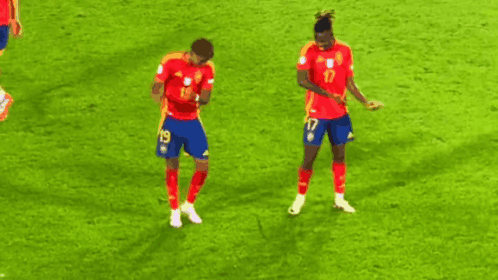 two soccer players are dancing on the field and one has the number 17 on his shorts