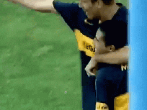 Two Soccer Players Are Hugging Each Other And One Has The Letter N On His Shirt GIF