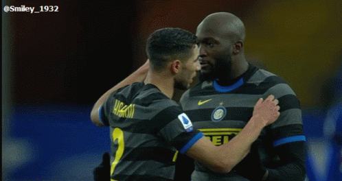 two soccer players are hugging each other and one has the number 1 on his shirt