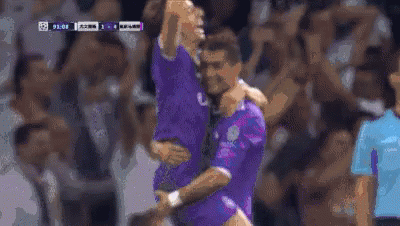 Two Soccer Players Are Hugging Each Other On The Field . GIF