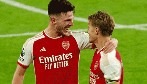Two Soccer Players Are Hugging Each Other On The Field . GIF