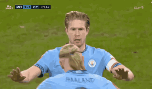 Two Soccer Players Are On A Field And One Has The Word Etihad On His Jersey GIF