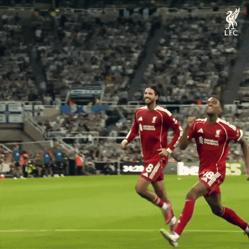Two Soccer Players Are Running On A Field And One Of Them Is Wearing A Jersey That Says Standard Chartered GIF