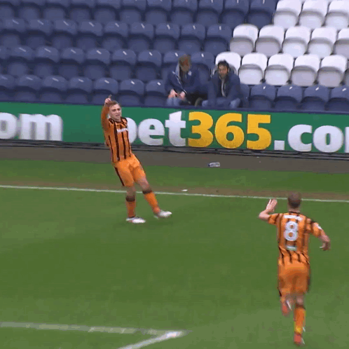 Two Soccer Players Are Running On A Field In Front Of A Sign That Says Bet365 GIF
