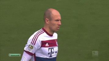 two soccer players are shaking hands on the field and one has the number 12 on his shirt