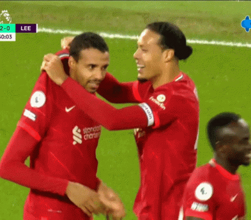 Two Soccer Players Hugging in Standard Charter Jerseys