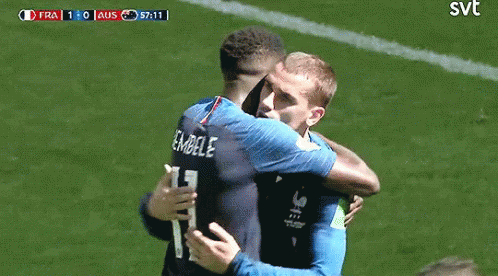 Two Soccer Players Hugging With SVT Logo on Field