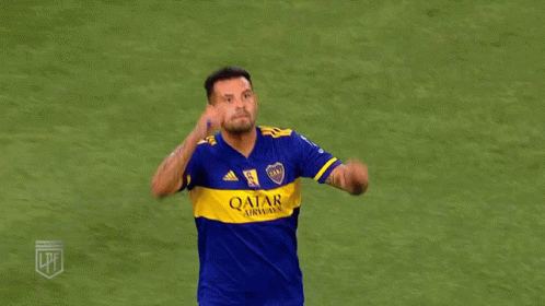 two soccer players in blue and yellow jerseys are hugging each other on a field .