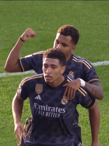 Two Soccer Players in Emirates Fly Better Jerseys Celebrate on Field