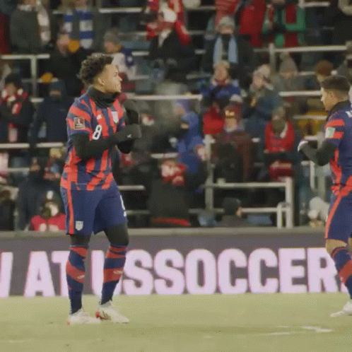 Two Soccer Players in Front of Soccer Sign