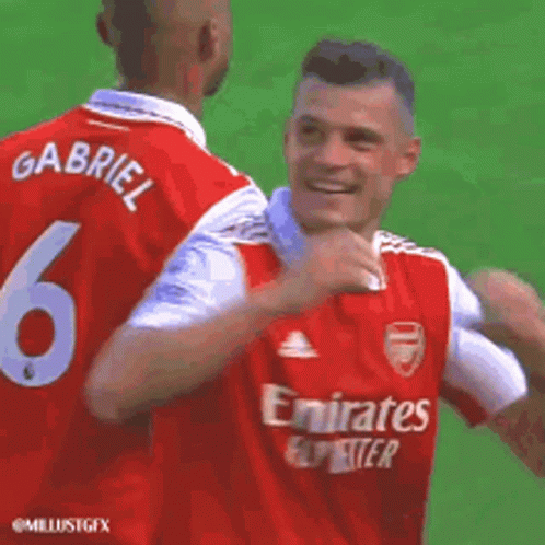 Two Soccer Players In Red Jerseys Hugging GIF