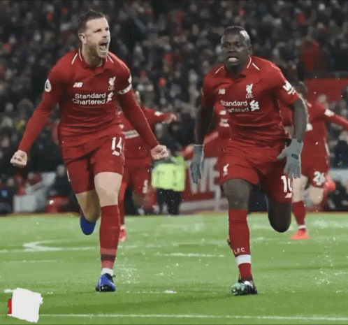 Two Soccer Players in Red Standard Chartered Jerseys