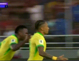 Two Soccer Players in Yellow and Green Jerseys Celebrating Goal