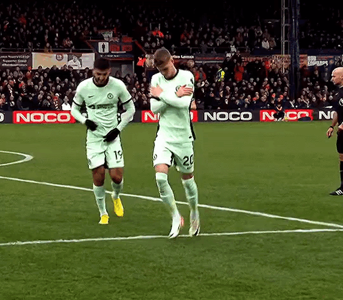 Two Soccer Players On A Field With A Noco Ad Behind Them GIF