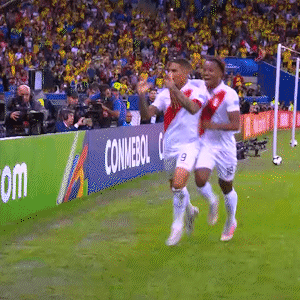 Two Soccer Players Running On A Field With A Conmebol Banner In The Background GIF