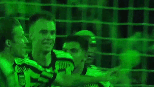 Two Soccer Players Standing In Front Of Green Background GIF