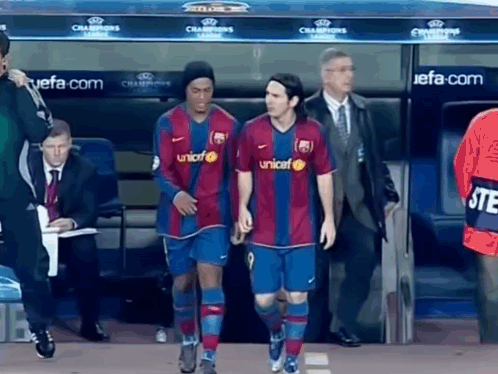 Two Soccer Players Walking Past Champions League Dugout