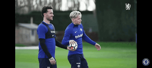 Two Soccer Players Wearing Blue Shirts That Say Trivago GIF
