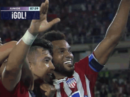 two soccer players with olympica on their shirts are celebrating a goal