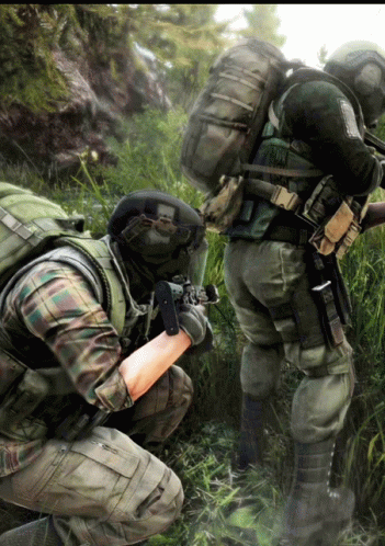 Two Soldiers Are Kneeling Down In The Grass And One Has A Backpack That Says Us Army GIF