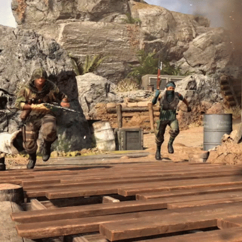 Two Soldiers Are Running Across A Wooden Bridge With A Barrel In The Background That Says ' Reichspartei ' On It GIF