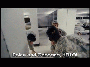 Two Soldiers Are Standing In A Room With The Words " Dolce And Gabbana Hello " On The Screen GIF