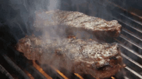 Two Steaks Cooking on Grill