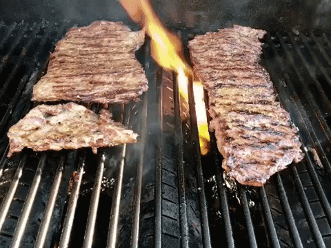 Two Steaks on Grill With Flames