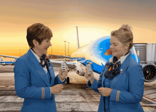 Two Stewardess Holding Small Houses by KLM Plane