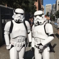 Two Stormtroopers Standing Next To Each Other On A Street GIF