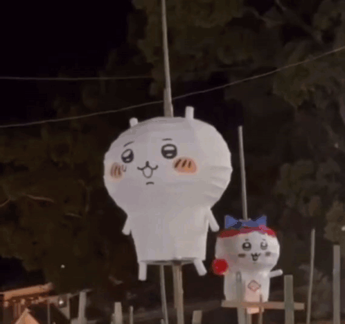 Two Stuffed Animals Are Hanging From A Rope In The Dark . GIF