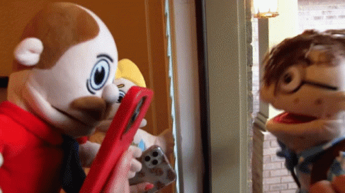 Two Stuffed Animals Looking at Phone