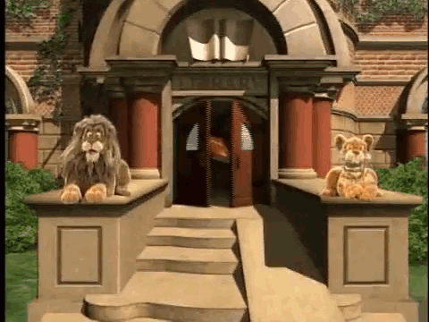 Two Stuffed Lions Are Sitting On The Steps Of A Building In Front Of A Building . GIF