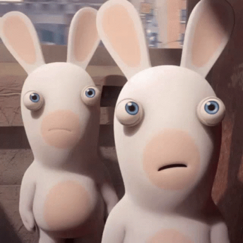 Two Stuffed Rabbits Staring With Big Blue Eyes GIF